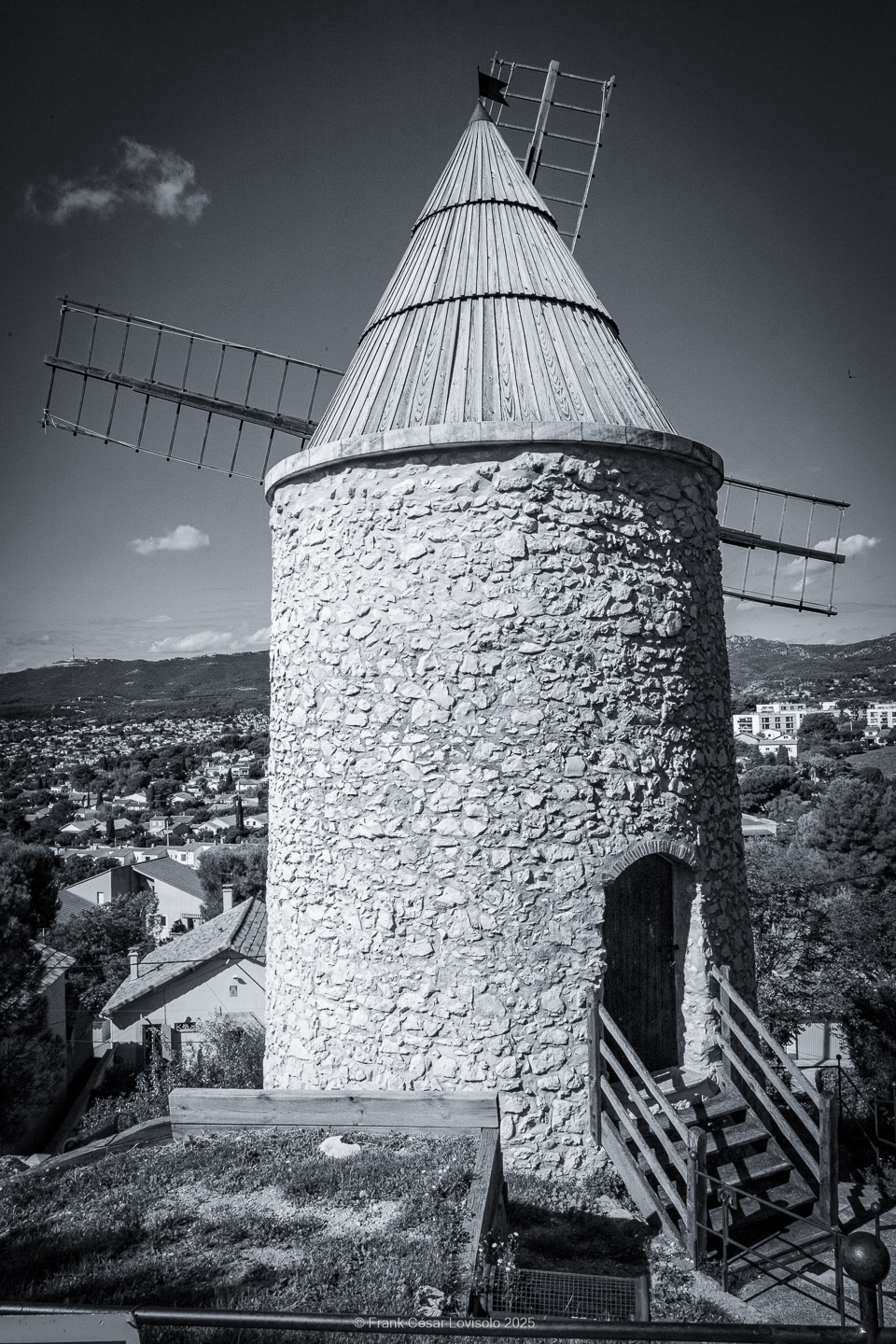 Allauch,Provence - Voyage - Frank César LOVISOLO - Allauch : Un nom qui résonne comme une chanson claire au cœur des collines provençales. Quand on le prononce, il semble que le vent s’y accroche, qu’il prolonge la dernière syllabe dans un souffle chaud ou vif quant aux saisons. Allauch, c’est la lumière du matin qui se pose sur les toits de tuiles d'argile orange, c’est le soir qui descend doucement sur les moulins ; c’est le parfum des pins mêlé à celui de la farigoule et du romarin. Ce village, suspendu entre ciel et mer, n’est pas seulement un espace géographique : il demeure un temps continu, une respiration de mémoire. Ici, l’histoire humaine s’est enracinée très tôt. Des vestiges antiques témoignent de la présence romaine, puis le Moyen Âge a dressé sur la colline son château, forteresse protectrice dont les ruines veillent encore.