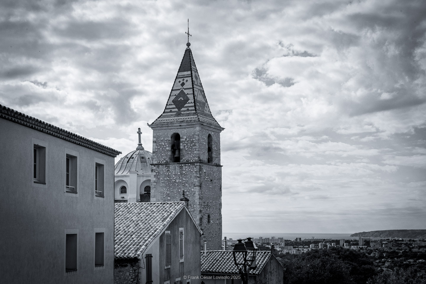 Allauch,Provence - Voyage - Frank César LOVISOLO - Allauch : Un nom qui résonne comme une chanson claire au cœur des collines provençales. Quand on le prononce, il semble que le vent s’y accroche, qu’il prolonge la dernière syllabe dans un souffle chaud ou vif quant aux saisons. Allauch, c’est la lumière du matin qui se pose sur les toits de tuiles d'argile orange, c’est le soir qui descend doucement sur les moulins ; c’est le parfum des pins mêlé à celui de la farigoule et du romarin. Ce village, suspendu entre ciel et mer, n’est pas seulement un espace géographique : il demeure un temps continu, une respiration de mémoire. Ici, l’histoire humaine s’est enracinée très tôt. Des vestiges antiques témoignent de la présence romaine, puis le Moyen Âge a dressé sur la colline son château, forteresse protectrice dont les ruines veillent encore.